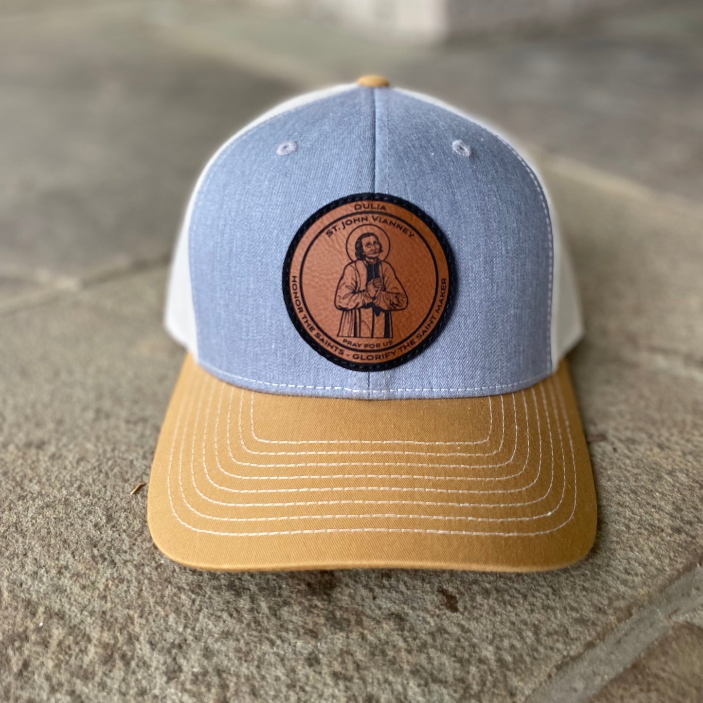 Leather patch trucker hat with St John Vianney